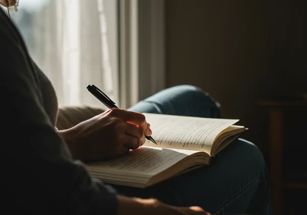 Person journaling to process feelings after screening results