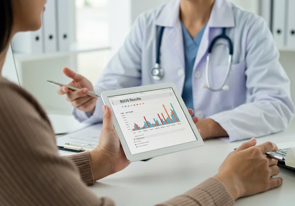 Patient calmly showing BSDS screening results to a doctor.